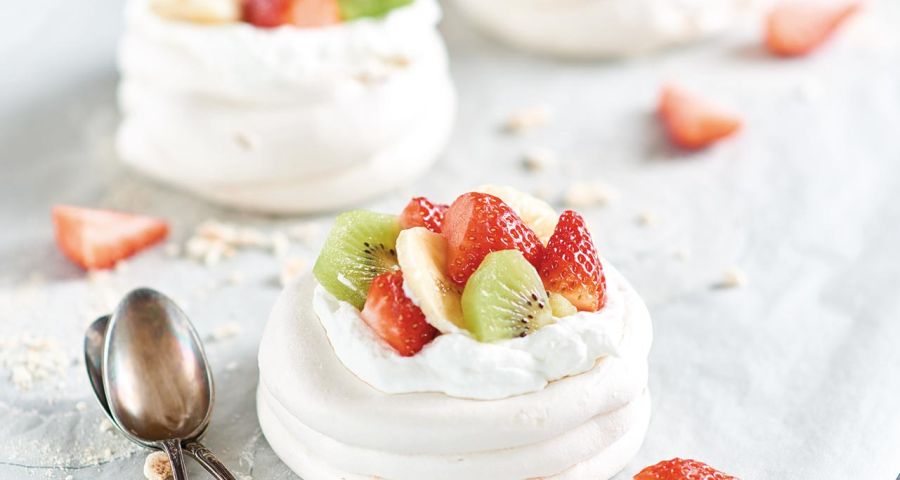 Mini pavlovas with strawberries, kiwi fruit and bananas