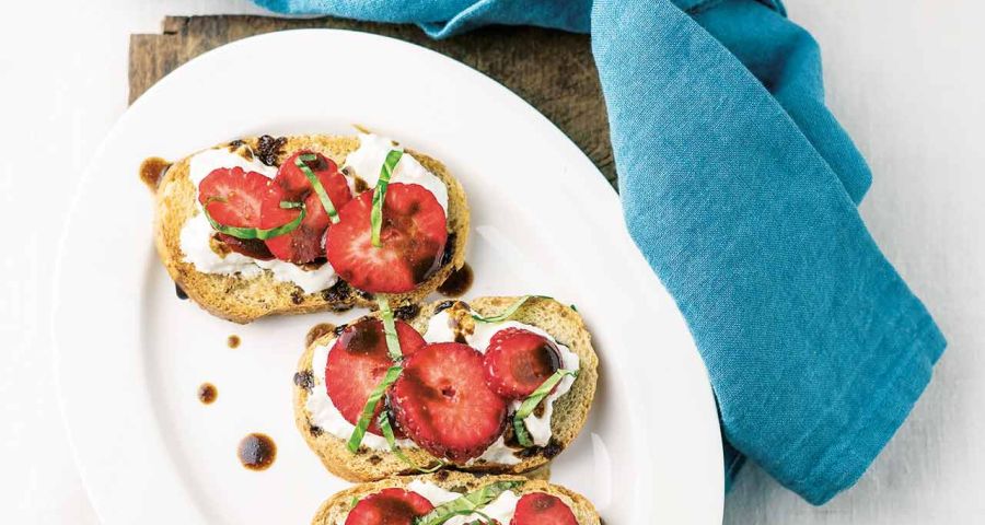 Crostoni (toasted slices of bread) with strawberries and stracciatella cheese